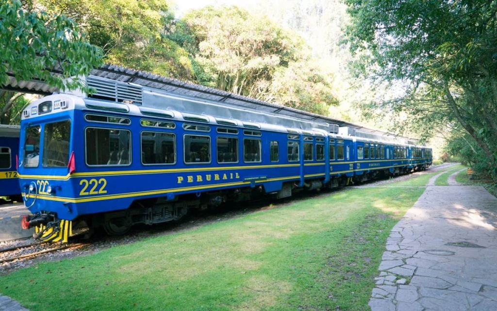 Tren azul de PeruRail junto al camino en la ruta a Machu Picchu
