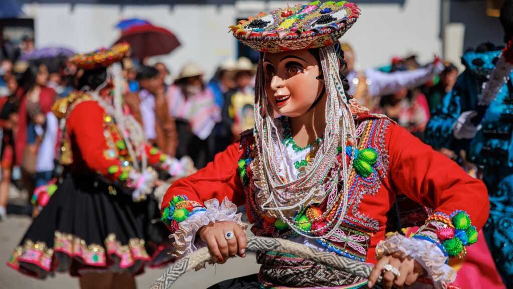 Comparsas de danzantes con vestimentas coloridas recorriendo las calles del Cusco