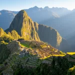 Cusco Histórico - Vista panorámica de Machu Picchu con montañas verdes y nubes alrededor.