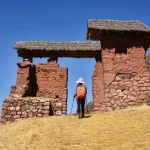Senderistas recorriendo los caminos de Huchuy Qosqo, con vistas a las terrazas agrícolas y al Valle Sagrado.