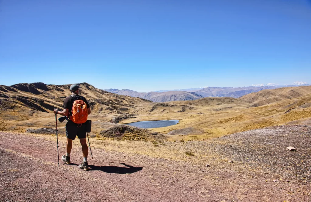 Grupos de viajeros explorando las antiguas ruinas de Huchuy Qosqo, disfrutando del paisaje montañoso y el Valle Sagrado.