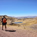 Grupos de viajeros explorando las antiguas ruinas de Huchuy Qosqo, disfrutando del paisaje montañoso y el Valle Sagrado.