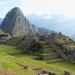 Aventura Cusco - Senderista en el Valle Sagrado con terrazas incas y montañas al fondo.