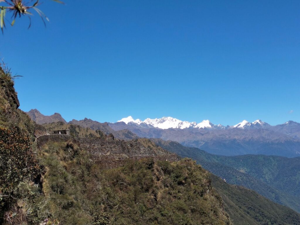 Ruinas incas en la ladera con la cordillera nevada al fondo en el Camino Inca de 4 días
