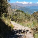 Sendero de piedra del Camino Inca con la cordillera nevada al fondo