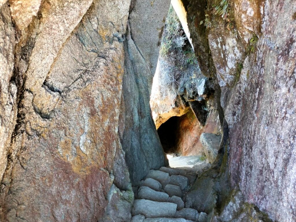 Túnel inca tallado en la roca con escalinatas de piedra en el Camino Inca de 4 días