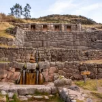 Tren hacia Machu Picchu rodeado de montañas y vegetación exuberante.