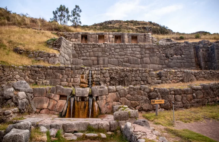Tren hacia Machu Picchu rodeado de montañas y vegetación exuberante.