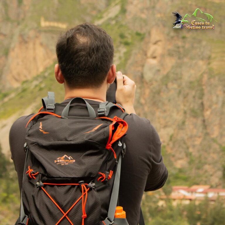 Viajero fotografiando los andenes incas de Ollantaytambo en el Valle Sagrado