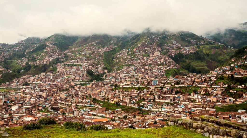 Vista de la ciudad de Cusco en temporada de lluvias, con los cerros verdes cubiertos de nubes