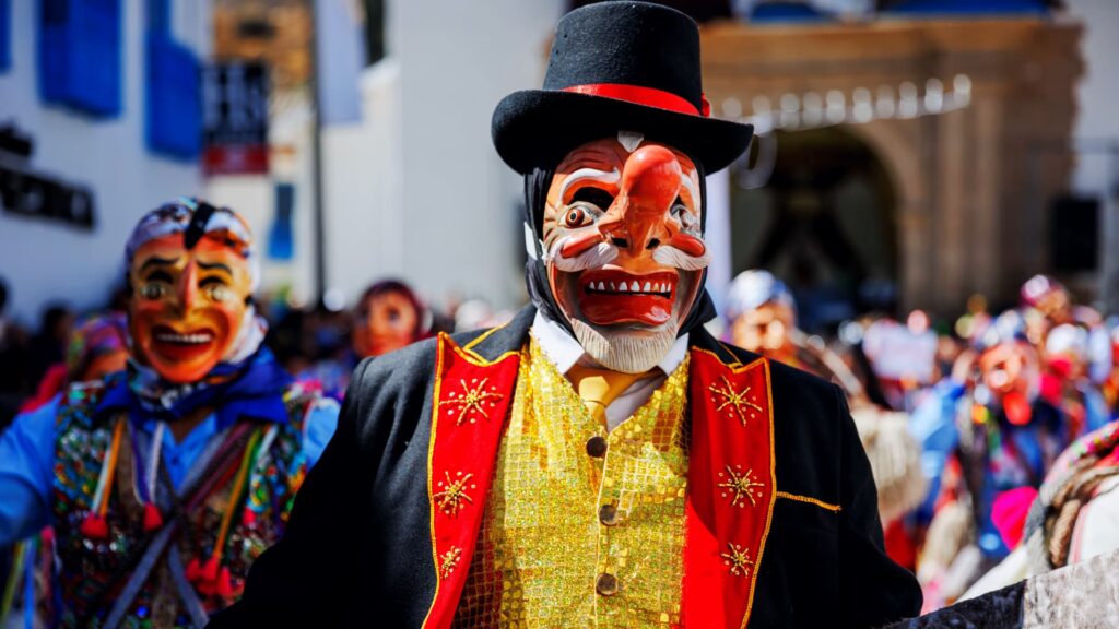 Danzante con máscara y traje festivo en una celebración tradicional de Cusco