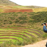Fotografía en Cusco: visitante capturando las impresionantes terrazas circulares de Moray en el Valle Sagrado