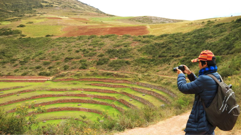 Fotografía en Cusco: visitante capturando las impresionantes terrazas circulares de Moray en el Valle Sagrado