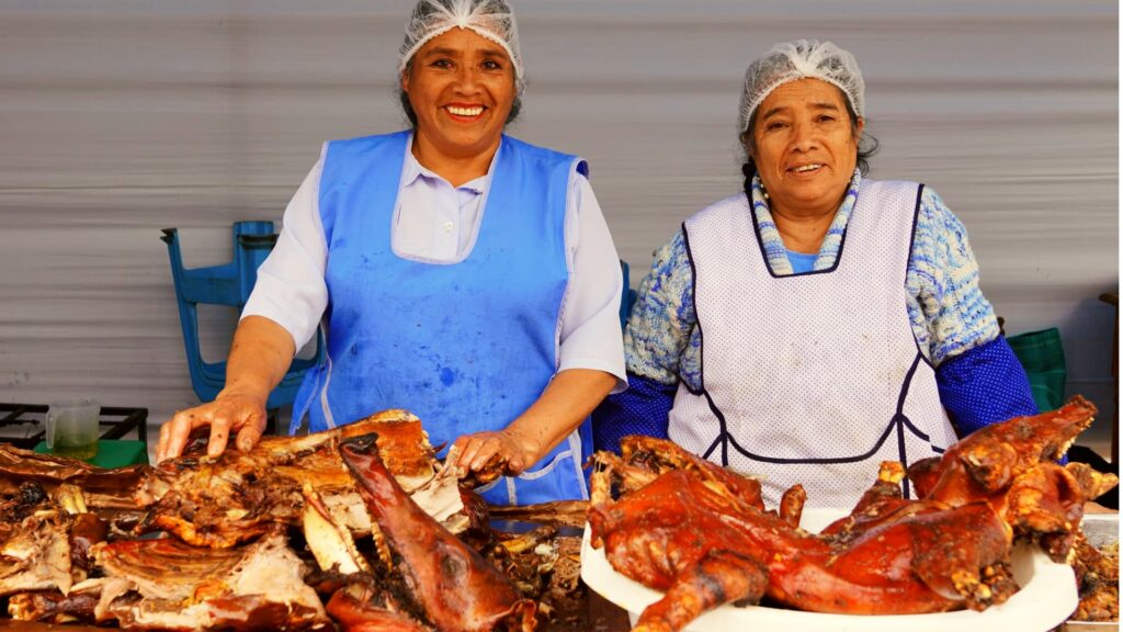 Lechón cusqueño horneado en horno de leña, con la piel dorada y crujiente