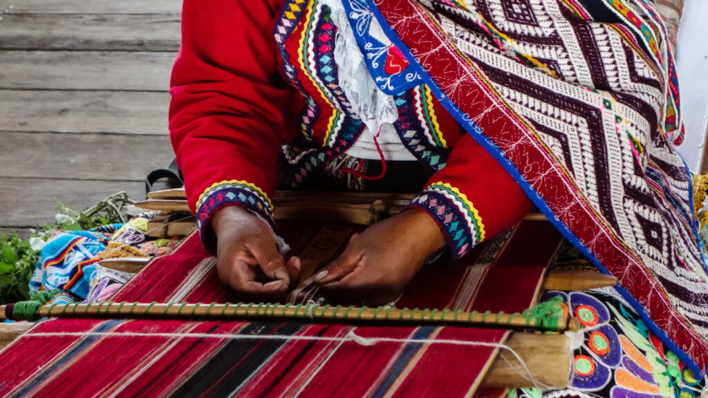 Mujer andina tejiendo en telar de cintura, técnica tradicional de la artesanía de Cusco