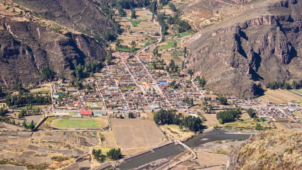 Vista aérea del pueblo de Lamay, rodeado de campos de cultivo y montañas en el Valle Sagrado