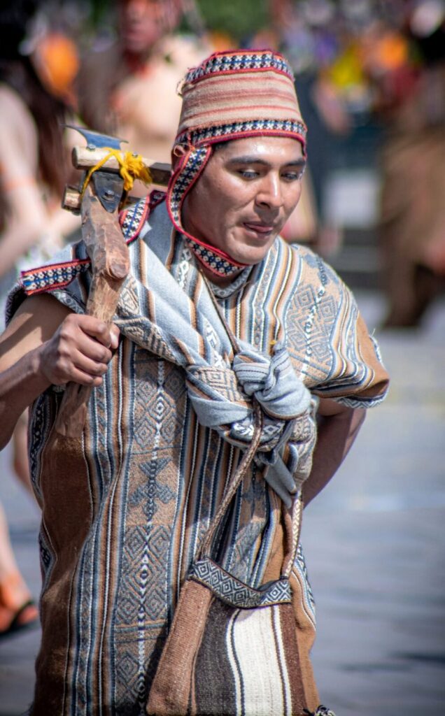 Hombre con chullo y vestimenta tradicional andina en una celebración en Cusco