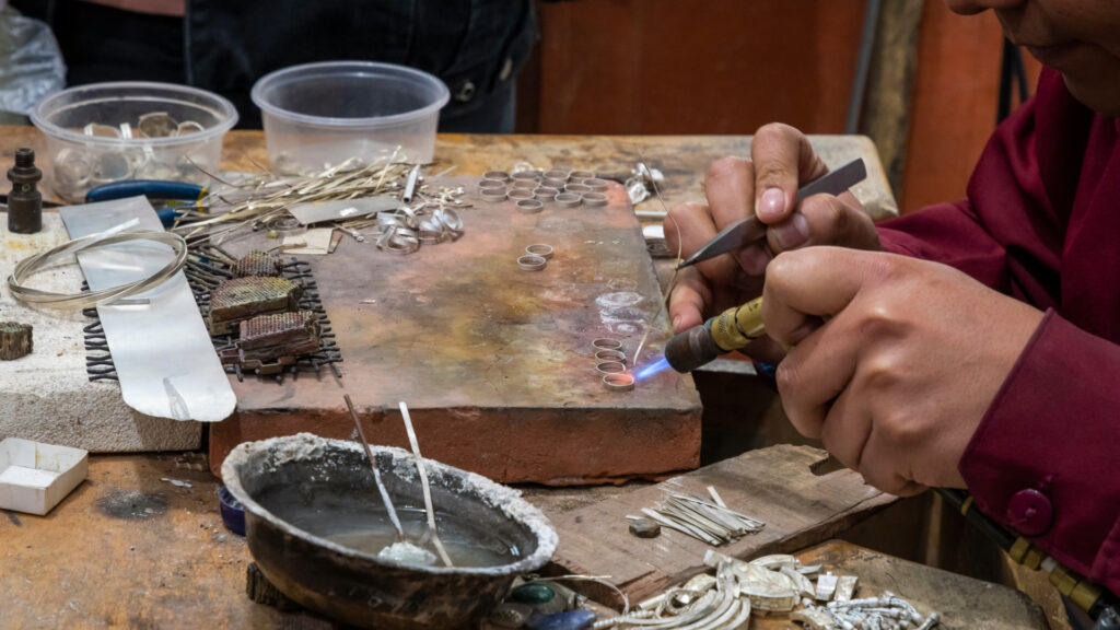 Artesano trabajando la plata en un taller de joyería de Cusco