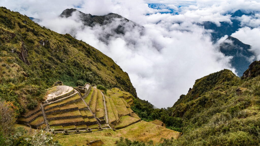 Terrazas de Phuyupatamarca rodeadas de nubes y montañas en el Camino Inca a Machu Picchu
