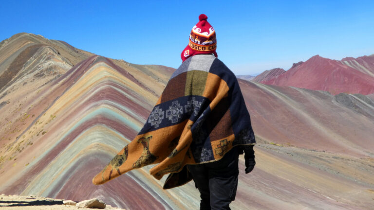 Viajero frente a la Montaña de Siete Colores observando la Geología de Vinicunca en todo su esplendor - Cusco tu Destino Travel