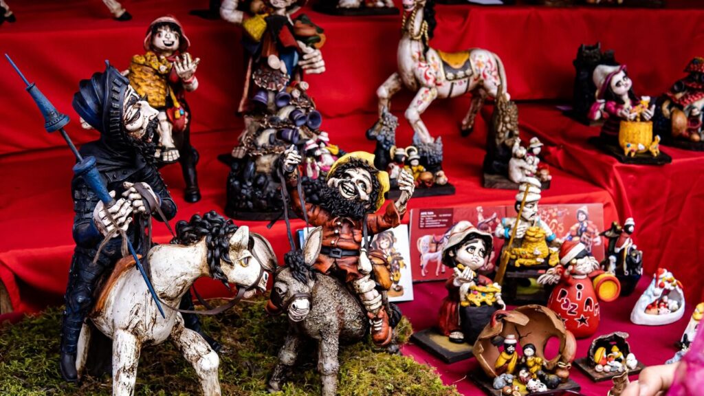 Figuras de imaginería cusqueña con jinetes y santos en una feria artesanal de Cusco