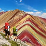Excursionistas con mochilas caminando por el sendero que lleva a la cumbre de la Montaña de 7 Colores, Vinicunca.