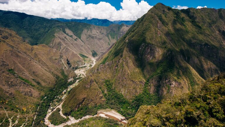 Vista panorámica desde lo alto del Camino Inca - Inka Jungle, mostrando el profundo cañón del río Urubamba serpenteando entre majestuosas montañas verdes.