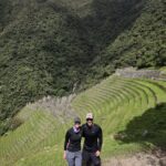 Caminantes junto a andenes incas en curva en el Camino Inca corto