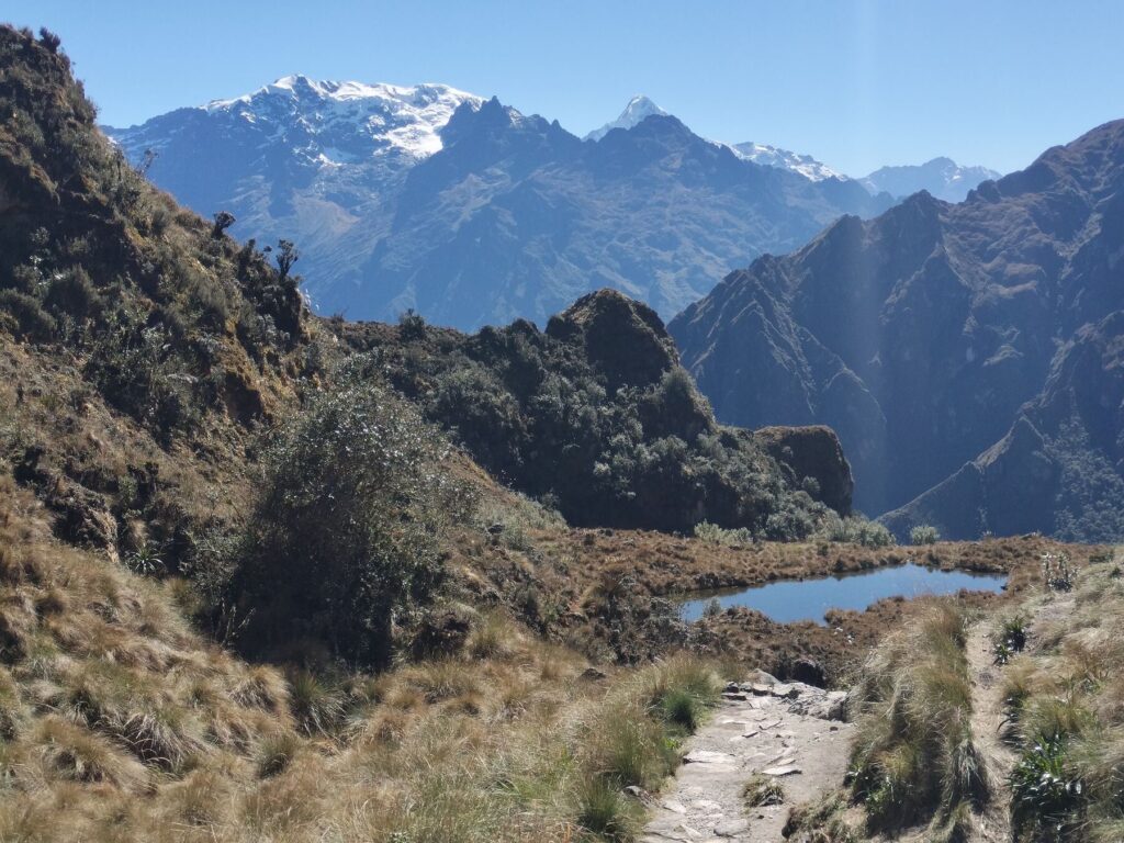 Laguna de altura bajo montañas nevadas en el Camino Inca de 4 días
