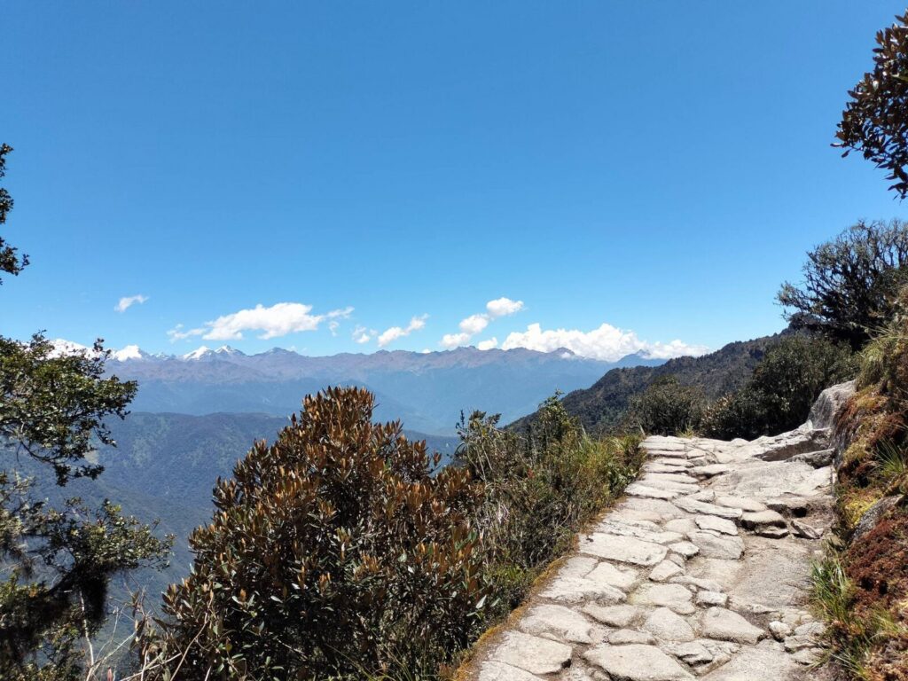 Sendero de piedra del Camino Inca con vista a la cordillera nevada