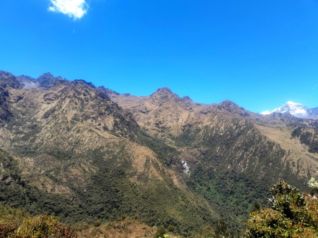 Valle andino con una cascada y un nevado visto desde el Camino Inca