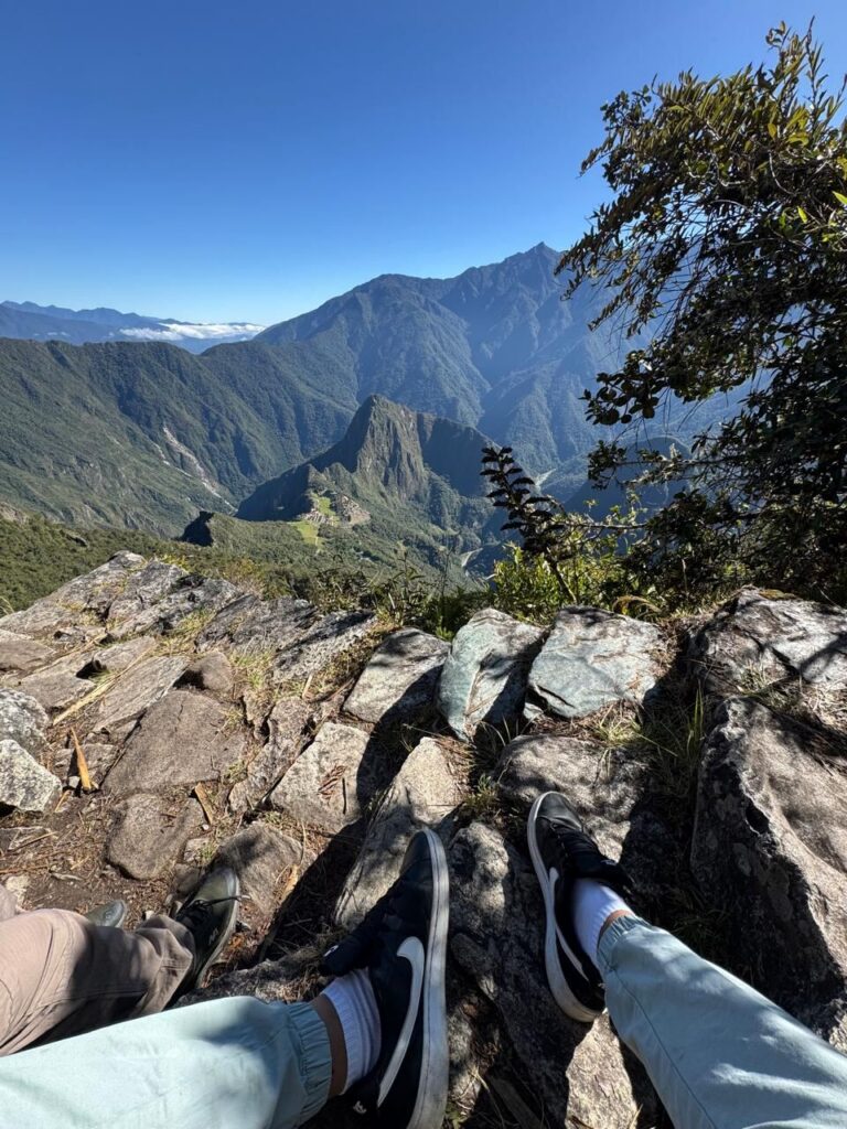 Descanso en las rocas de la cumbre de la Montaña Machu Picchu con vista al valle