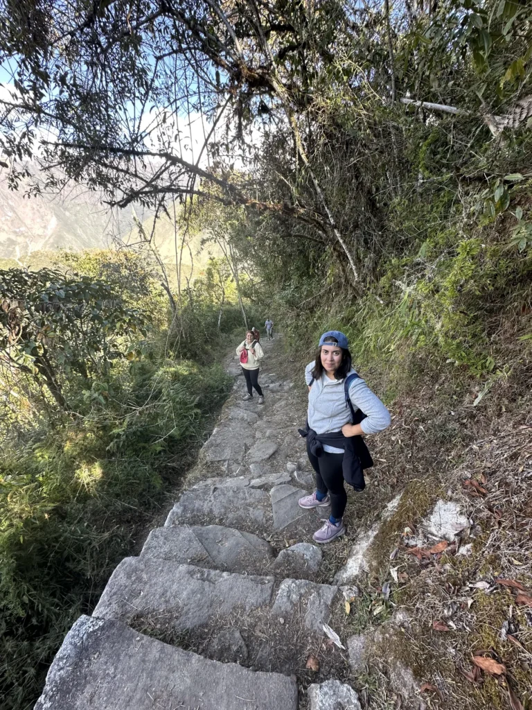 Viajera subiendo una escalinata inca en el bosque: así son muchos tramos del Camino Inca