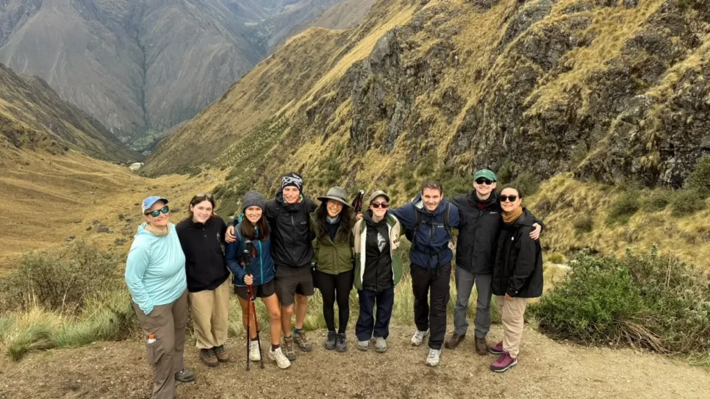Grupo de viajeros en la puna del Camino Inca, con el valle al fondo