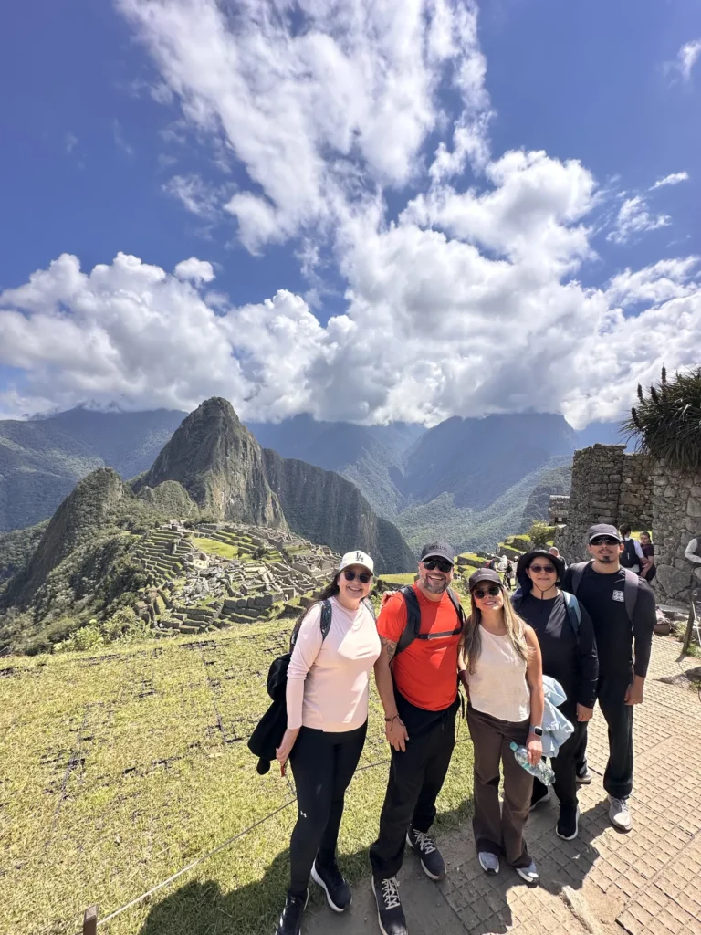 Grupo de viajeros en la foto clásica de Machu Picchu, con el Huayna Picchu al fondo