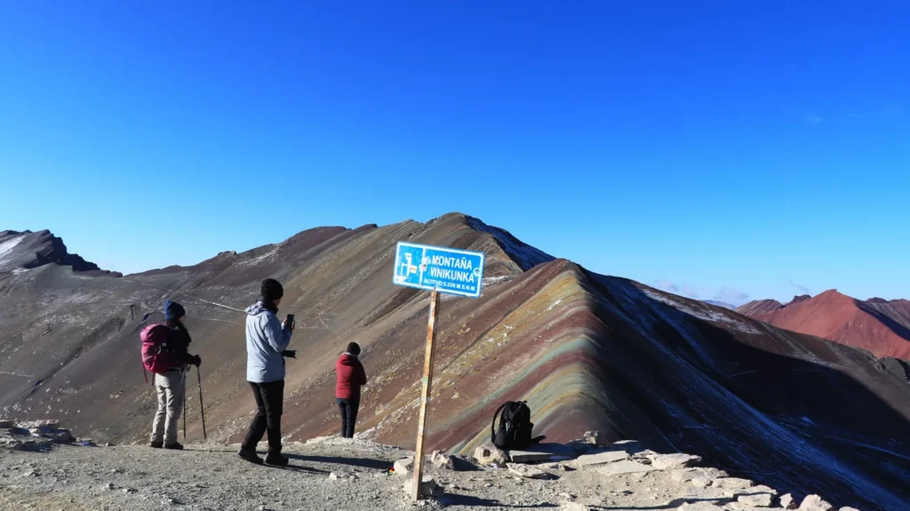 Viajeros junto al letrero de la Montaña Vinicunca, que marca 5,036 m s. n. m.