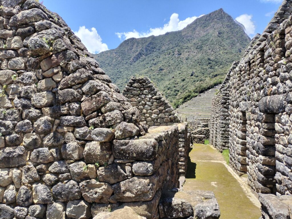 Calle inca entre recintos de piedra en Machu Picchu