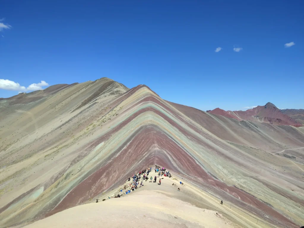 Mirador de la Montaña de 7 Colores (Vinicunca) con viajeros, bajo un cielo despejado