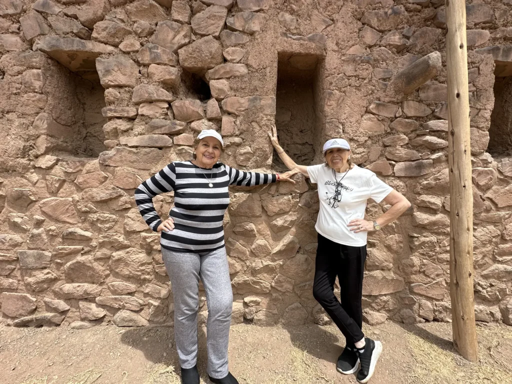 Viajeras junto a un muro inca con hornacinas en el parque arqueológico de Pisac