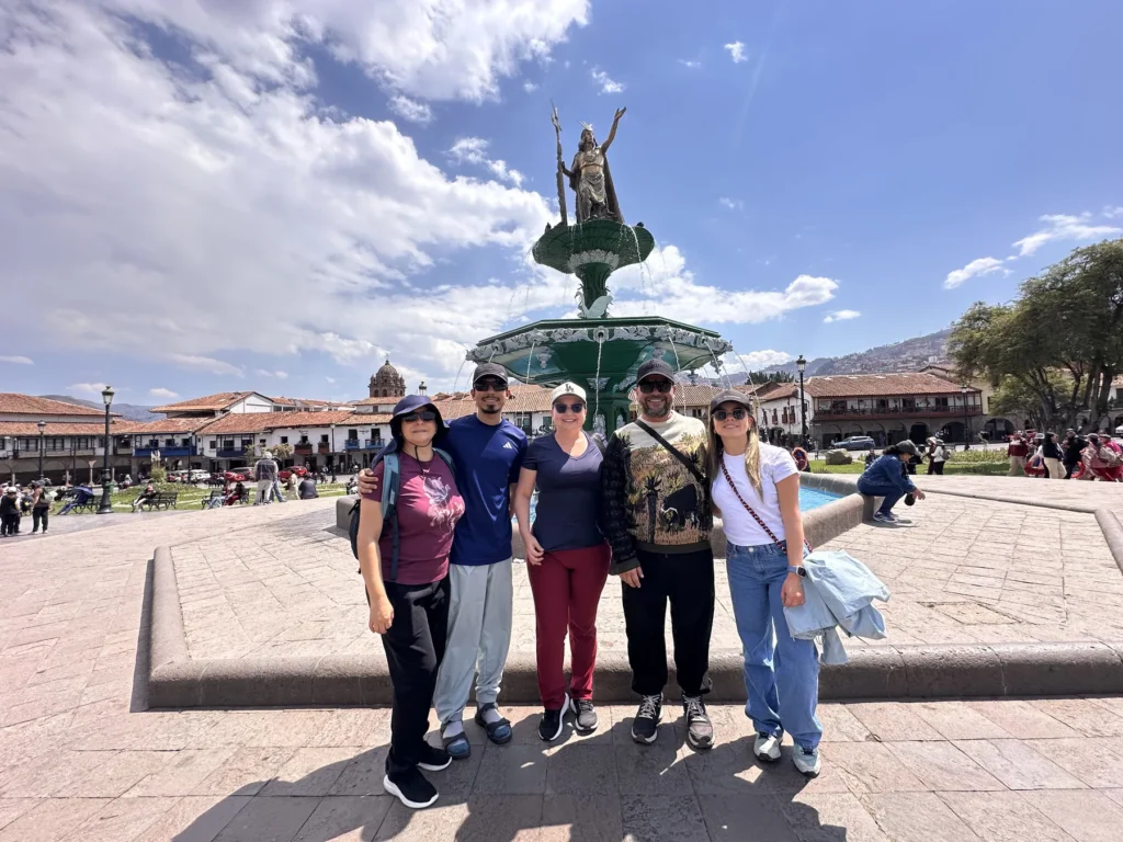 Grupo de viajeros en la Plaza de Armas del Cusco, junto a la fuente de Pachacútec