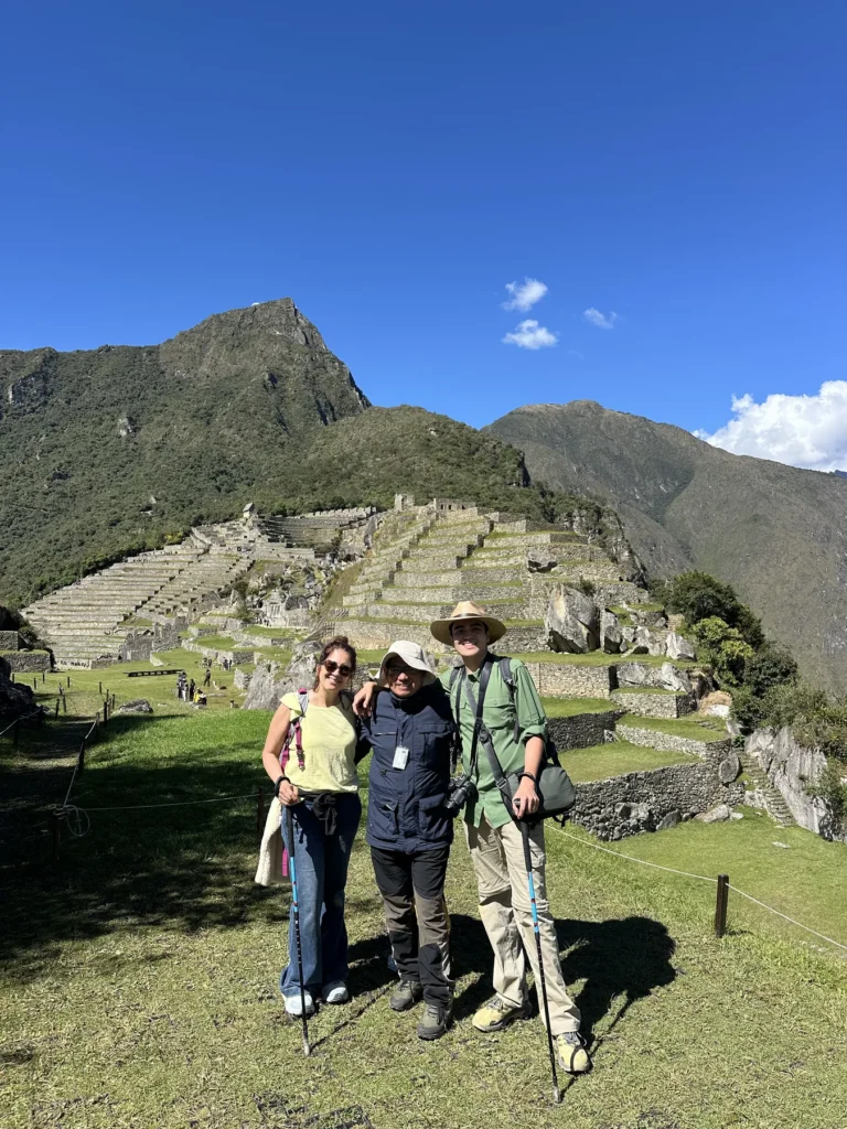 Viajeros del Camino Inca llegando a Machu Picchu en un día soleado