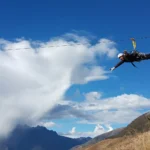 Viajero en la tirolesa (zip line) de Cusco, volando sobre el valle